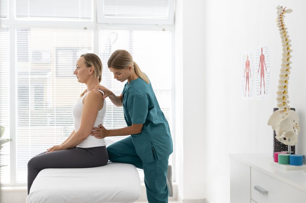 young physiotherapist helping patient with back problems